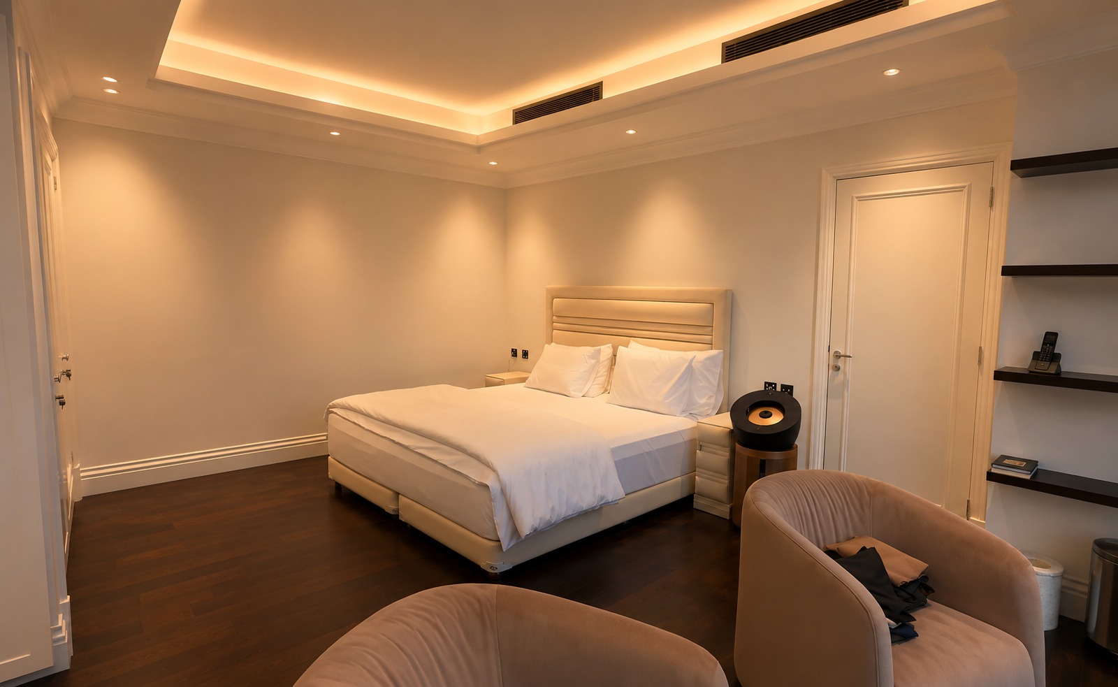 Bedroom with warm cove lighting and low-glare recessed downlights